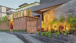 Un bâtiment moderne doté d’une façade en bois, d’un escalier en béton et d’une entrée bien éclairée.