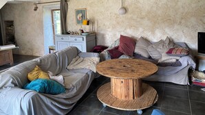 Een rustieke woonkamer met een houten salontafel, twee banken en een stenen muur.