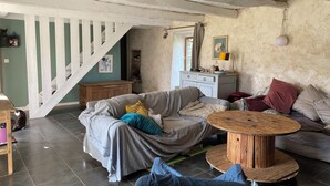 Een gezellige woonkamer met een trap, een houten tafel en een bank.