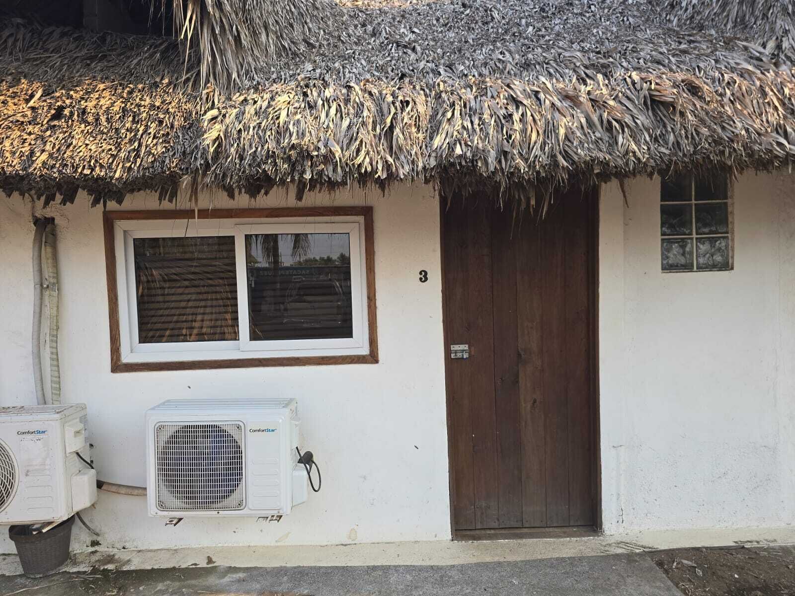 A small house with a thatched roof, a window, and a door.