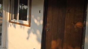 A wooden door with a metal handle and a window with a white frame. - Hot Chipilin El Paredon (Sipacate)