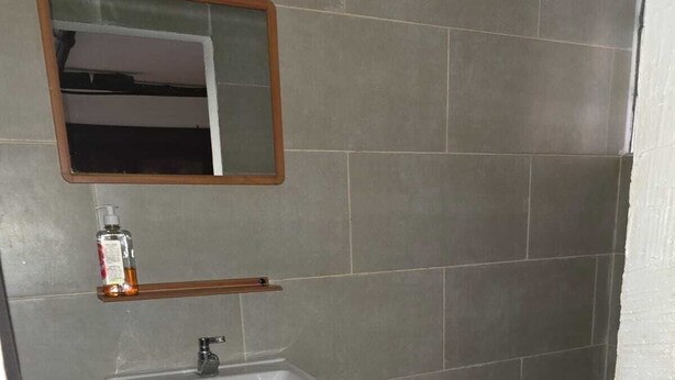 A bathroom with a white sink, a mirror above it, and a toilet. - Hot Chipilin El Paredon (Sipacate)