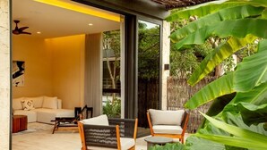 A modern living room with a sofa, two armchairs, and a coffee table. - Bloom Tulum | Two 2-BR Apartment |  w/ Private Terrace Near Tulum Ruins (Tulum)