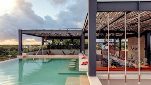 A pool area with lounge chairs, a bar, and a covered seating area with a thatched roof. - 1-BR 1 Queen | Bloom Tulum | w/ Fully Equipped Kitchen + Private Pool (Tulum)