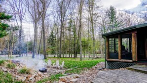 A rustic cabin with a porch, a hot spring, and a forested backdrop. - Rib Mountain Cabin (Wausau)