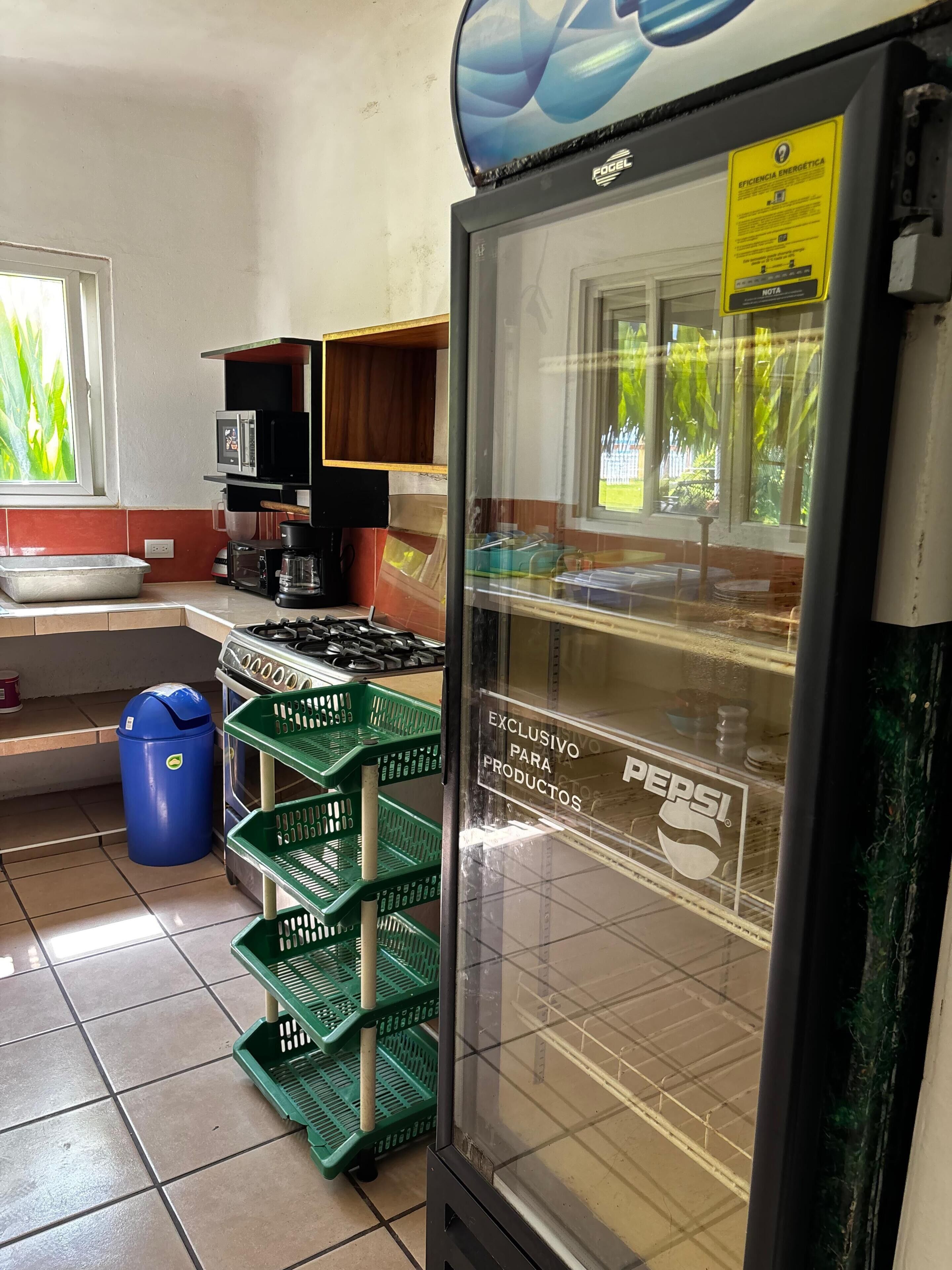 A kitchen with a refrigerator, microwave, and coffee maker.