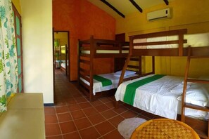Una habitación con literas, una mesita y una silla.