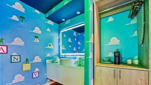 Ein Zimmer mit blaugrünen Farbtönen, einem Waschbecken, einem Spiegel und einem Holzschrank.