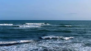 Blick auf den Ozean mit Wellen und blauem Himmel.