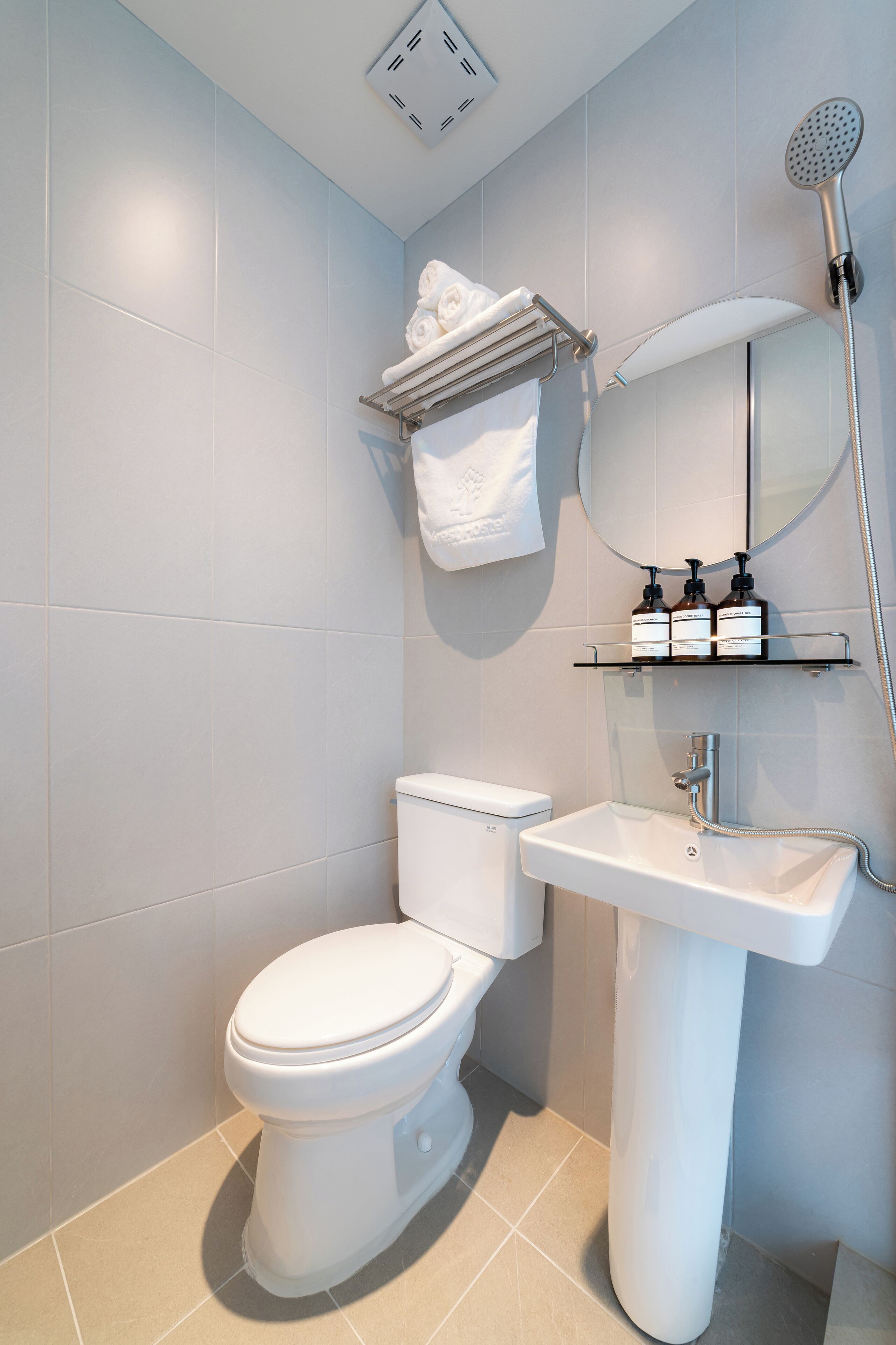 A modern bathroom with a toilet, sink, and shower.
