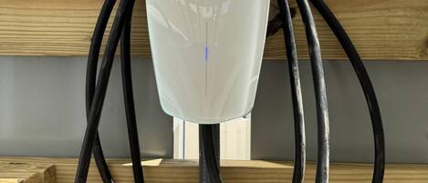 A Tesla charging station with a wooden structure in the background.