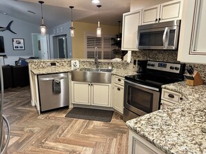 A kitchen with granite countertops, stainless steel appliances, and a herringbone wood floor. - Family-friendly, heated salt water pool, near beaches, and downtown Fort Myers. (Fort Myers)