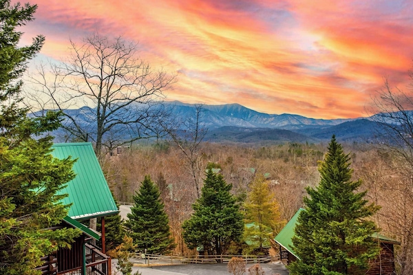 Relax on this expansive log cabin deck featuring rustic rocking chairs and stunning mountain views.