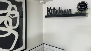 A kitchen with a black sign that reads "Kitchen" and a circular sign above it that says "home Sweet home". - Beautiful 2-bedroom house in tranquil Warren perfect for relaxing stays (Warren)