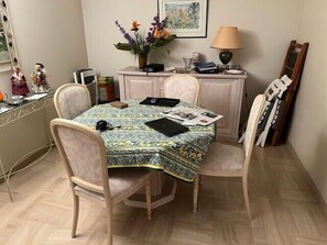 A dining area with a table covered by a patterned tablecloth, surrounded by four chairs. - Apartment in Port Fréjus with sea and marina views (Fréjus)