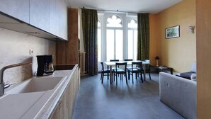 Eine moderne Küche mit Backofen, einer Kaffeemaschine und einem Essbereich mit Tisch und Stühlen.