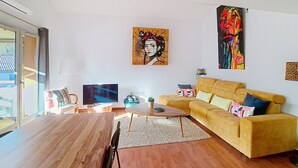 A modern living room with a sofa, a coffee table, a TV, and artwork on the walls. - Bel appartement à 3 min de la plage à La Ciotat (La Ciotat)