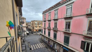 Une rue étroite bordée de bâtiments des deux côtés, avec des balcons et un passage piéton.