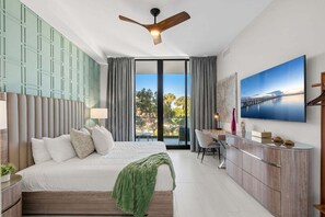 Ein modernes Schlafzimmer mit einem Bett, einem Schreibtisch und einem Fernseher.