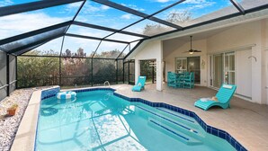 A covered outdoor swimming pool with a view of trees and a cityscape. - 218 Cherry Drive (Melbourne Beach)