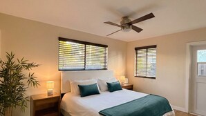 A bedroom with a bed, two bedside tables, a ceiling fan, and a potted plant. - Lux 3BD House, 5 Min To Holly Cross, HCA Hospital&Beaches (Oakland Park)