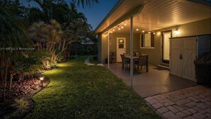 A house with a covered patio, a dining area, and a garage. - Lux 3BD House, 5 Min To Holly Cross, HCA Hospital&Beaches (Oakland Park)