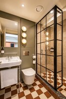 A bathroom with a sink, toilet, and a glass-enclosed shower area.