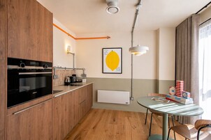 Eine moderne Küche mit Backofen, einer Kaffeemaschine und einer Wandleuchte.