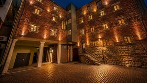 A multi-story building with a brick facade, multiple windows, and a staircase leading to an upper level. - Stay Hush (Edinburgh)