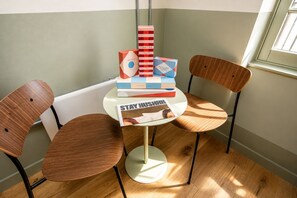 A corner room with a round table, two wooden chairs, and a window. - Stay Hush (Edinburgh)