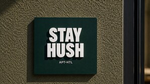 A sign with the text 'STAY HUSH' and 'APT. HTL' on a textured wall. - Stay Hush (Edinburgh)