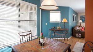 A dining area with a table, chairs, and a hanging light fixture. - Cozy 1-bedroom condo, in soothing Tucson with fitness room, pools & trails (Tucson)
