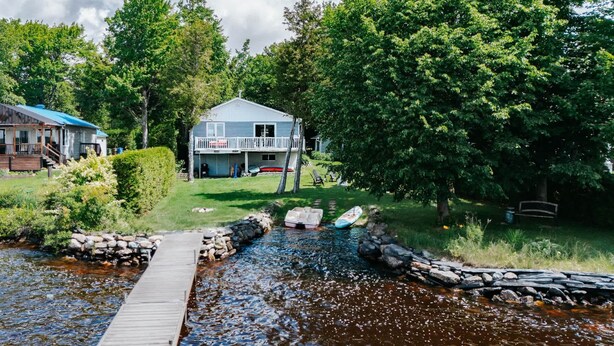 A house with a dock extending into a river, surrounded by trees and a grassy yard. - Comfort by the Aylmer Lake | Evasion du Douze59 (Beaulac-Garthby)