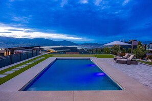 Una piscina amb vista a muntanyes i un paisatge urbà.