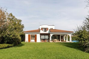 A two-story house with a white exterior and a red-tiled roof.