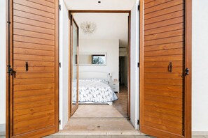 A bedroom with a bed, bedside table, and a mirror.