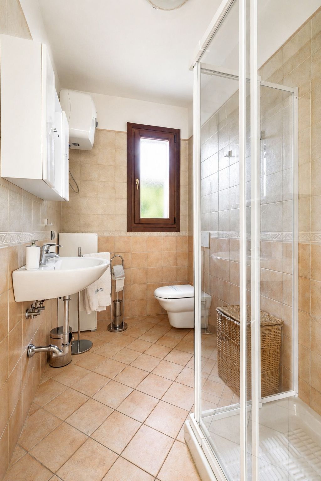 A bathroom with a glass shower enclosure, a white sink, a toilet, and a window.