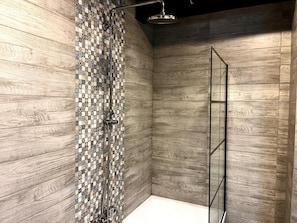 A shower with a mosaic tile wall and wooden paneling. - Modern Wood Loft | 7 Min to Colonnade (Karlovy Vary)