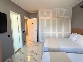 A hotel room with a bed, a wardrobe, and a television.