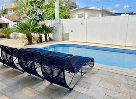 Une piscine avec des chaises longues et des palmiers.