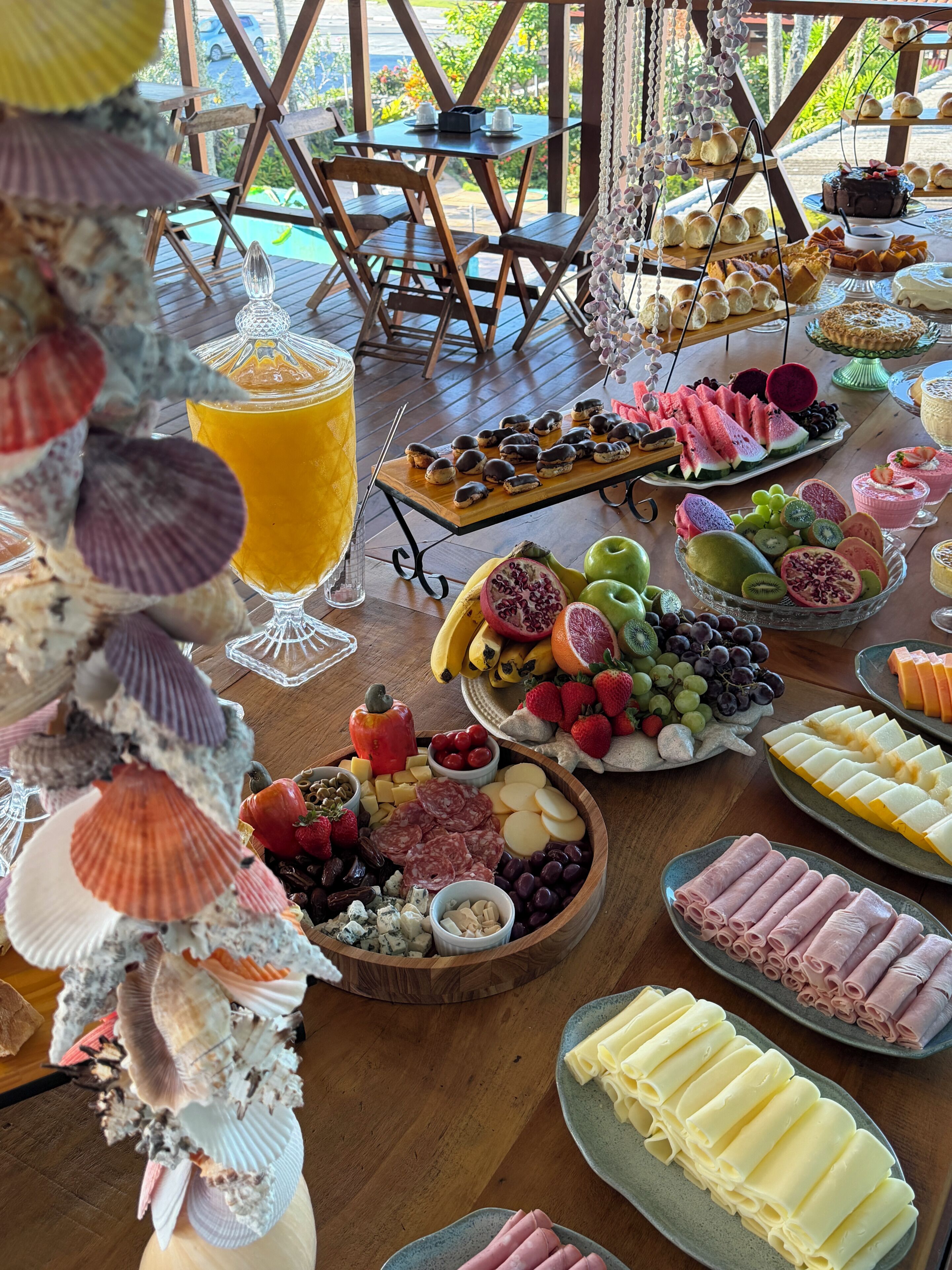 A buffet table with various food items and a glass of orange juice.