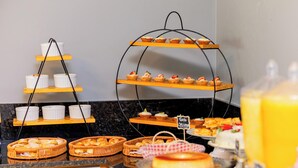 A buffet setup with various food items and a sign indicating 'Toka Salad'. - Santa Rita Pousada (Guarujá)