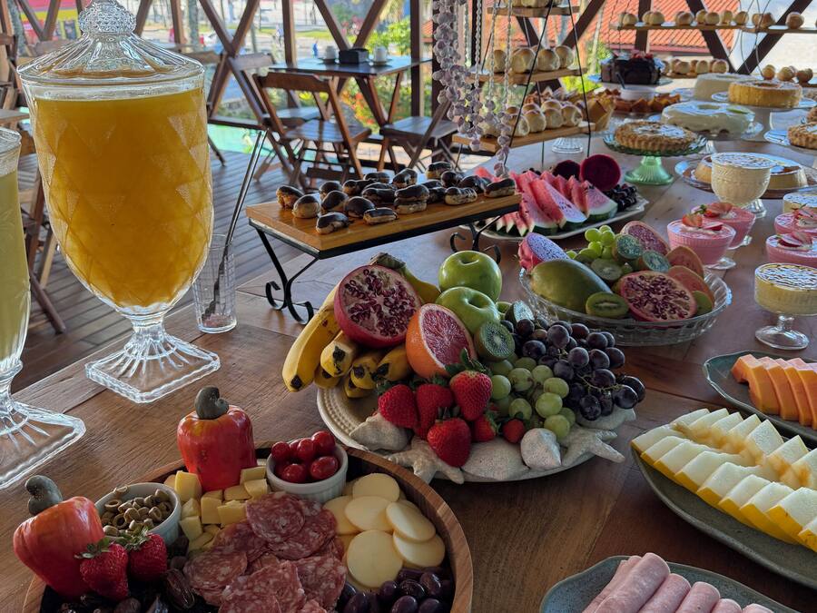 Una mesa de buffet con diversos alimentos y una bebida grande.