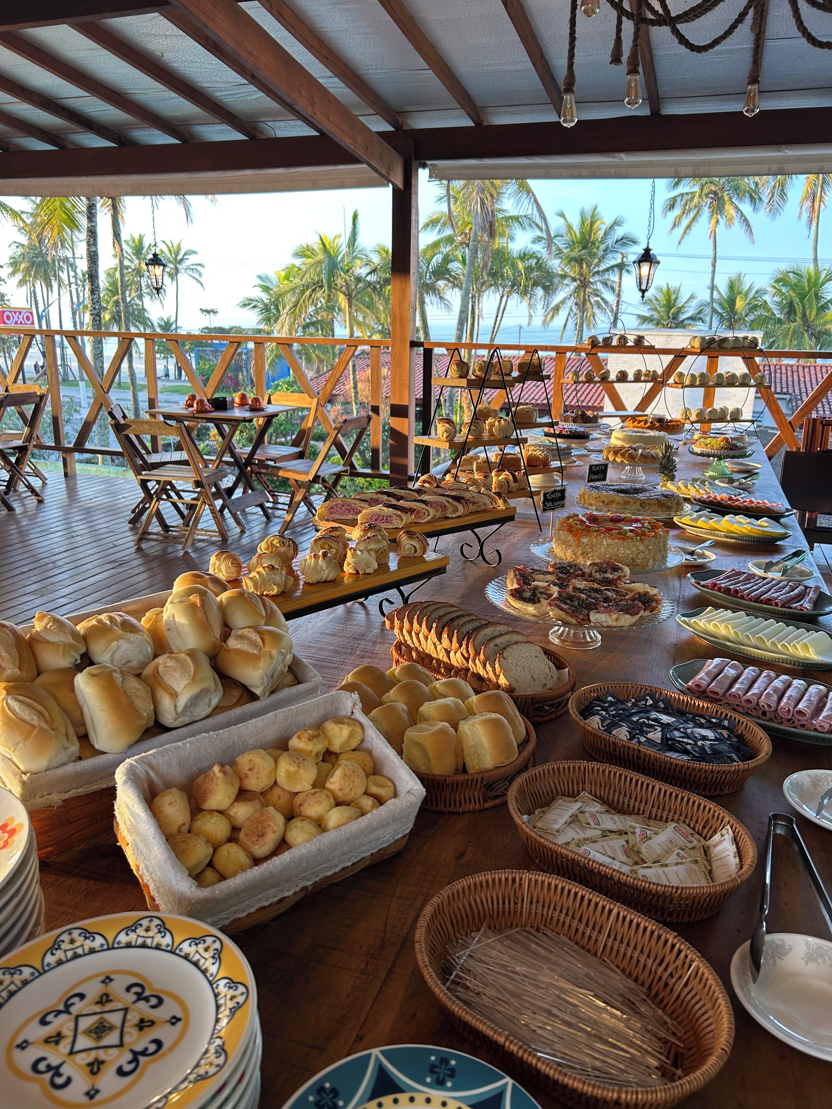 Una mesa de buffet con diversos alimentos y disposición de mesas y sillas.
