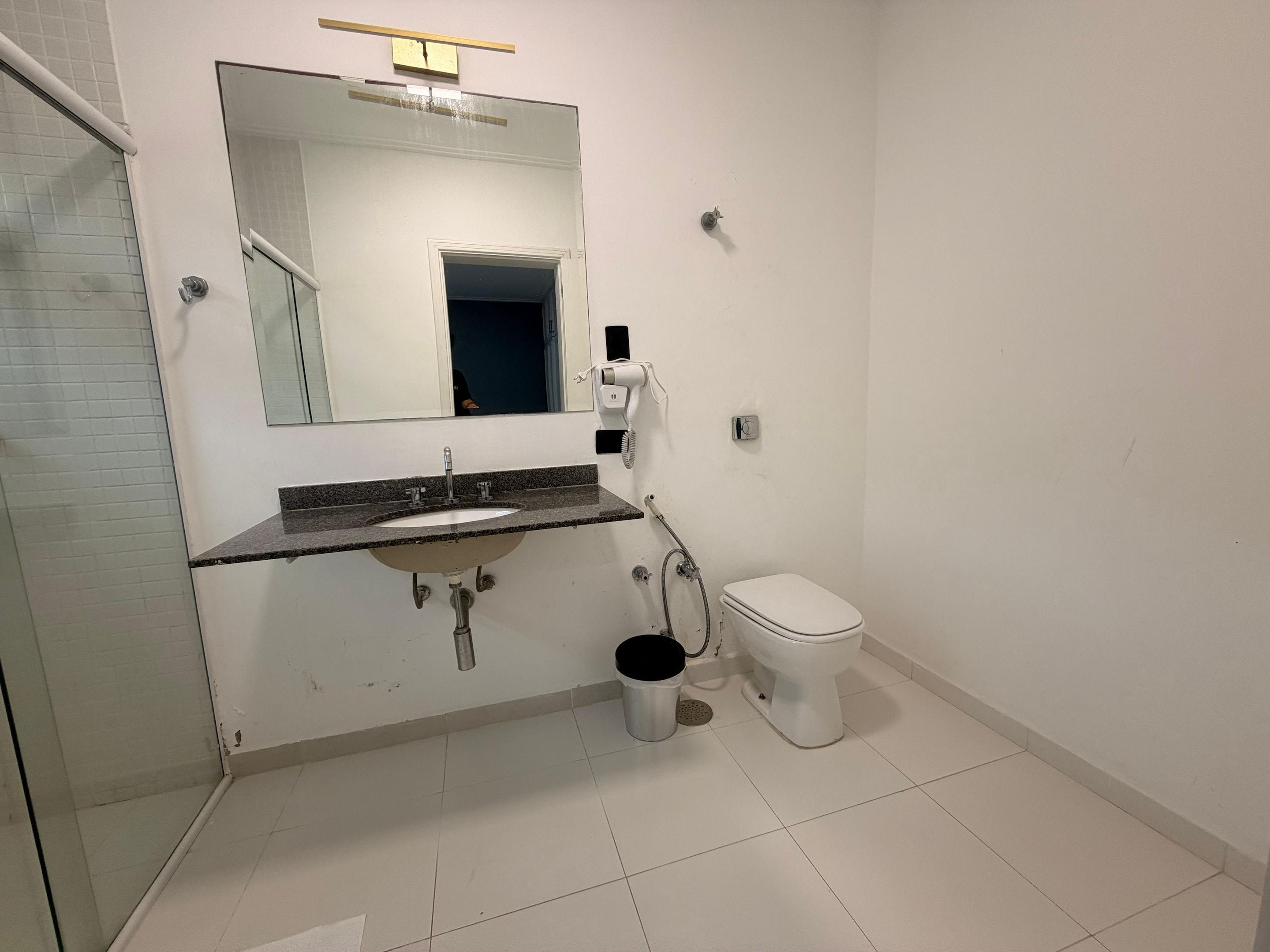 Une salle de bain avec un lavabo, des toilettes et un miroir.
