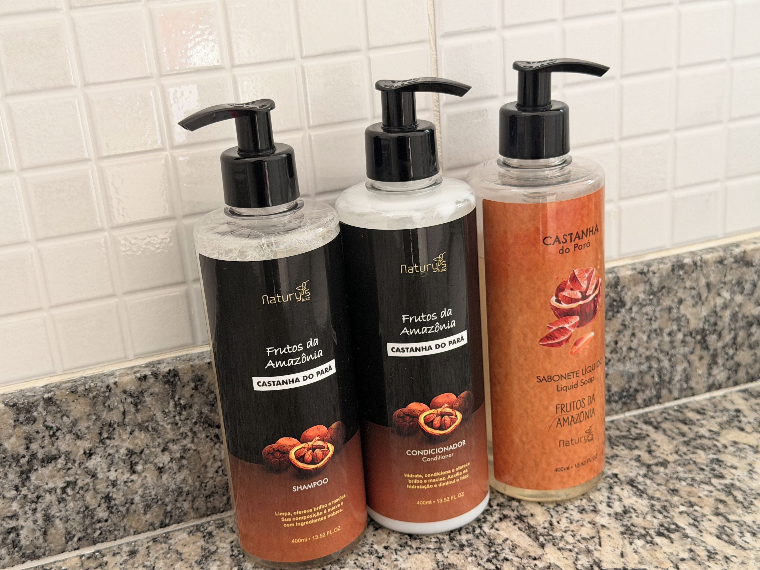 Three bottles of Naturyis products on a granite countertop.