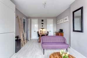 A compact living space with a sofa, a dining table, and a kitchen area.