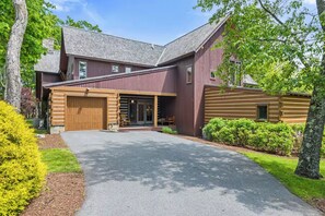 A two-story house with a garage, a covered porch, and a well-maintained lawn. - Spacious 5-bedroom house in serene McHenry with Hot Tub and Pet Friendly (McHenry)