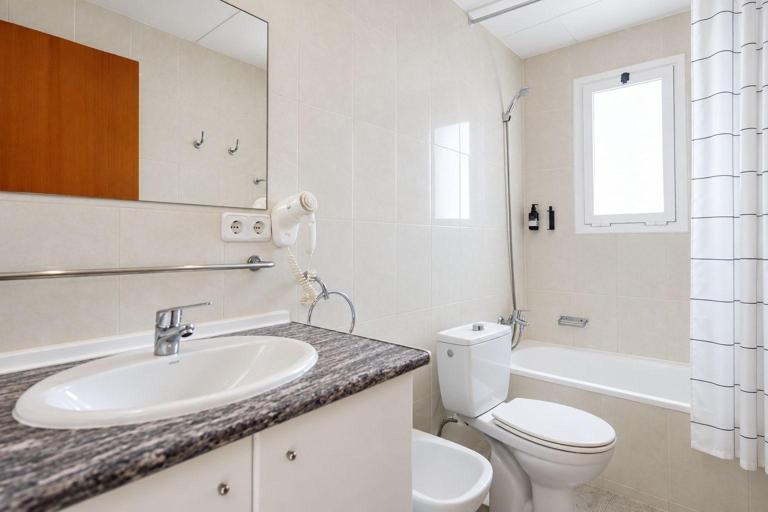 Un baño moderno con lavamanos, inodoro y bañera.