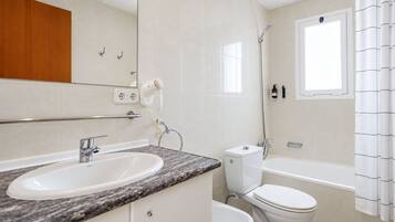 Un baño moderno con lavamanos, inodoro y bañera.